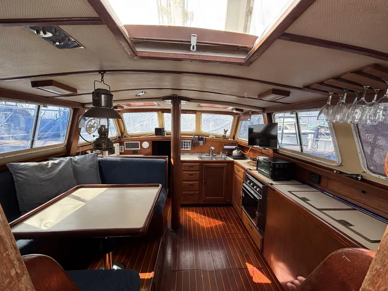 1973 CAL 246 yacht interior with wooden furnishings, dining area, and kitchen.