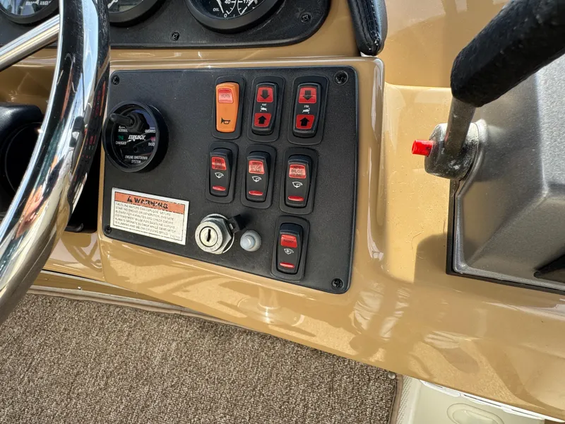 Control panel of 2004 Carver 366 Motor Yacht with switches and steering wheel.