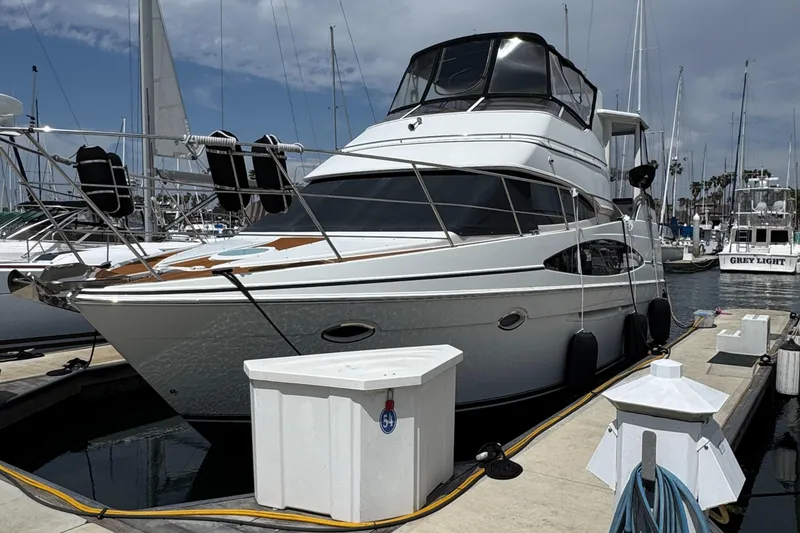 2004 Carver 366 Motor Yacht docked at a marina under a partly cloudy sky.