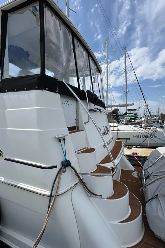 2004 Carver 366 Motor Yacht docked, featuring elegant steps and a covered upper deck.