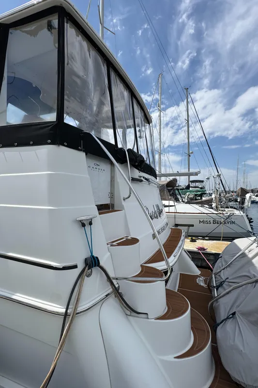 2004 Carver 366 Motor Yacht docked, featuring elegant steps and marina backdrop.