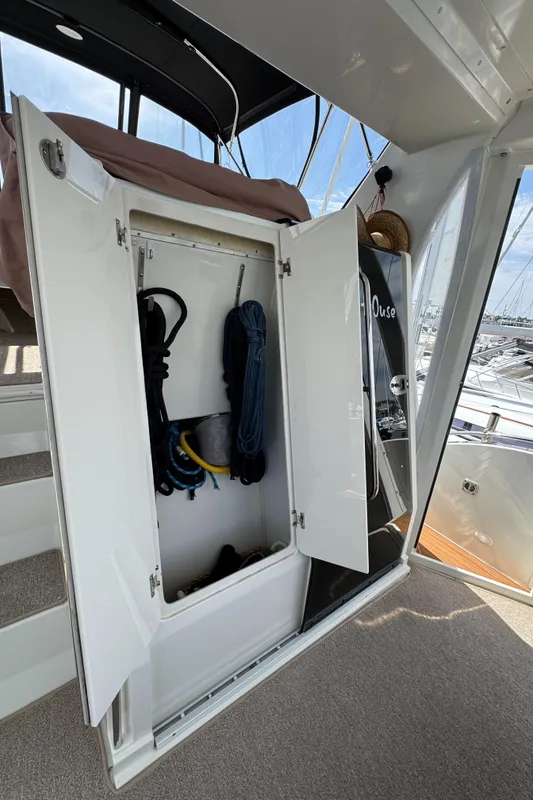 Open storage compartment on 2004 Carver 366 Motor Yacht, containing ropes and equipment.