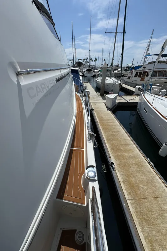 2004 Carver 366 Motor Yacht docked at marina, side view with wooden deck.