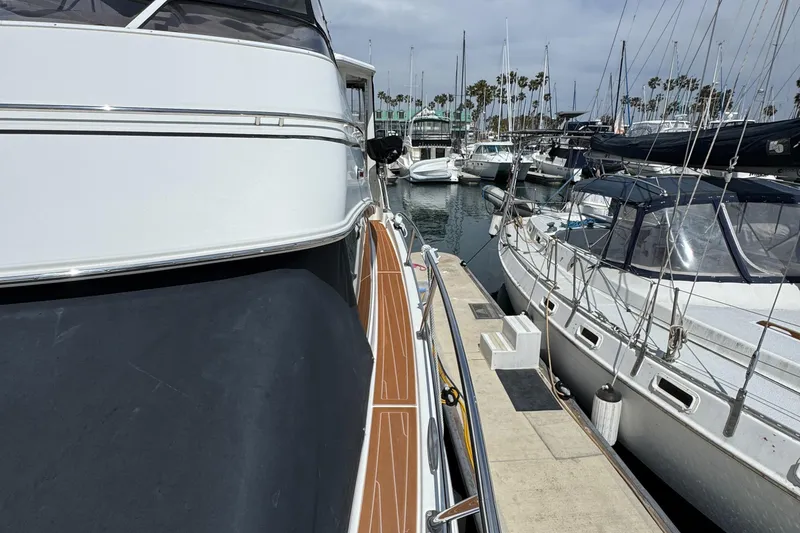 2004 Carver 366 Motor Yacht docked in a marina, surrounded by sailboats.