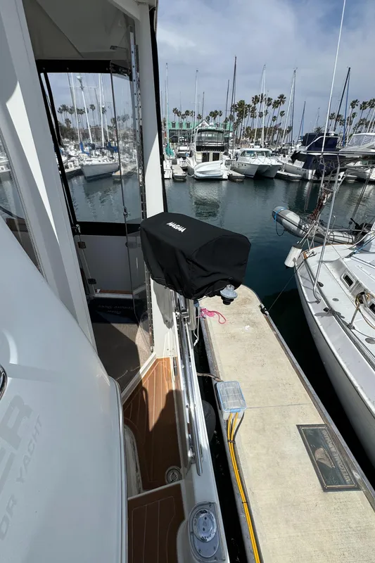 2004 Carver 366 Motor Yacht docked at a marina with sailboats in the background.