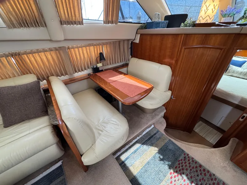 Interior of 2004 Carver 366 Motor Yacht with cozy seating and wooden accents.