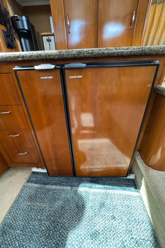 2004 Carver 366 Motor Yacht interior with wooden cabinetry and dual refrigerators.