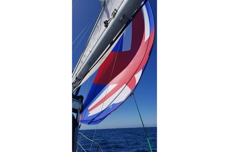 Sailboat with colorful spinnaker on open sea, Custom Bodega 30, 1977 model.