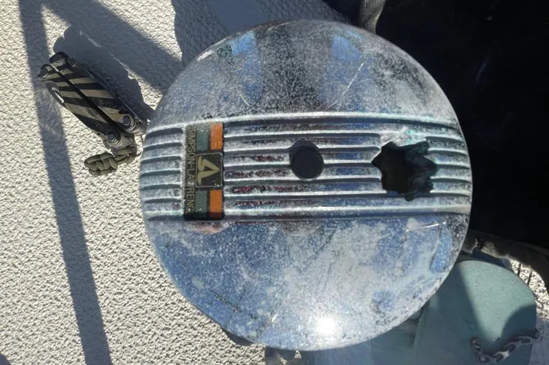Damaged piston from a 1977 Custom Bodega 30 engine, showcasing wear and tear.
