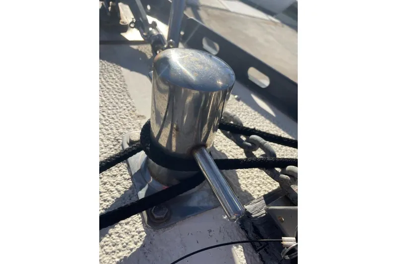 Stainless steel cleat on 1977 Custom Bodega 30 boat deck with ropes and chains.