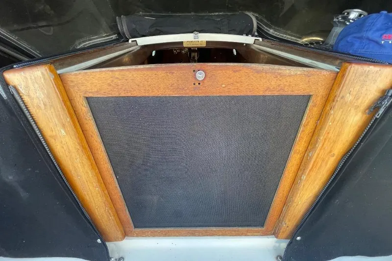 Wooden hatch of a 1977 Custom Bodega 30 boat, featuring a mesh screen.