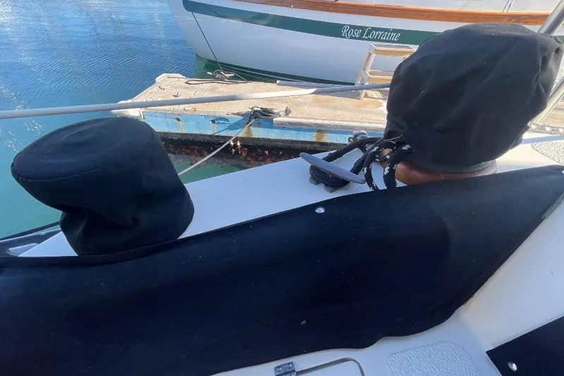 1977 Custom Bodega 30 boat with covered winches, docked near another vessel.