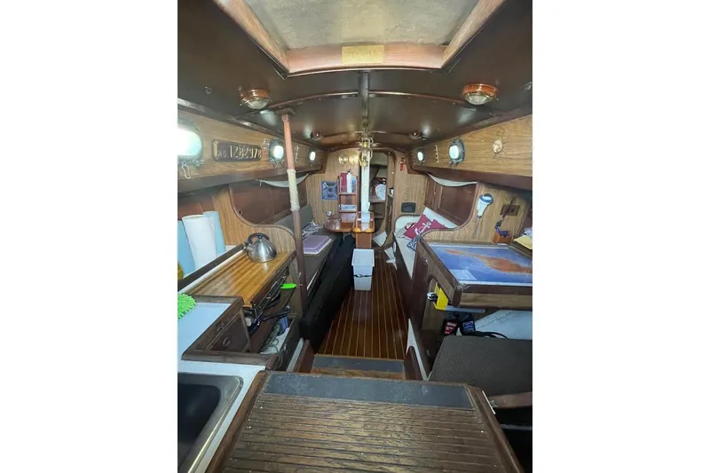 Interior of 1977 Custom Bodega 30 sailboat with wooden finishes and nautical decor.