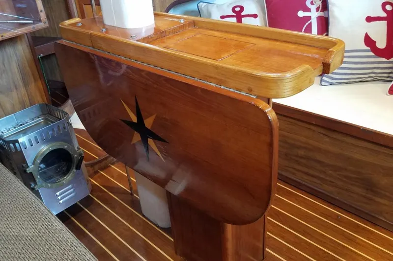 Wooden interior of 1977 Custom Bodega 30 boat with nautical decor and stove.