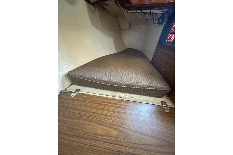 1977 Custom Bodega 30 interior cabin with brown cushion and wooden flooring.