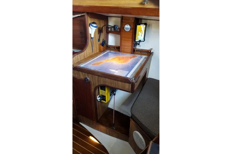 Navigation station inside a 1977 Custom Bodega 30 sailboat, featuring a nautical chart.