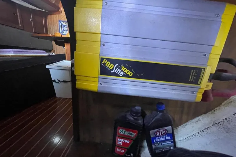 Yellow ProSine 1000 inverter in a 1977 Custom Bodega 30 interior with motor oil containers.