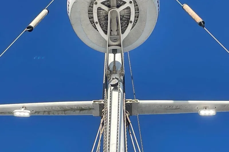 Close-up of Custom Bodega 30 sailboat mast against clear blue sky, 1977 model.