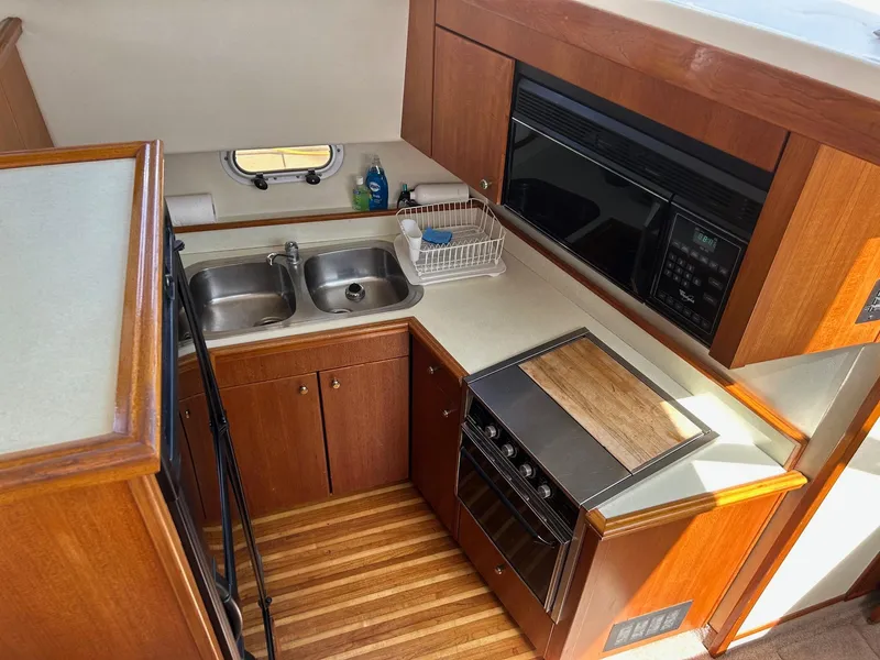 1994 Bayliner 4587 Motoryacht kitchen with dual sinks, stove, and microwave.