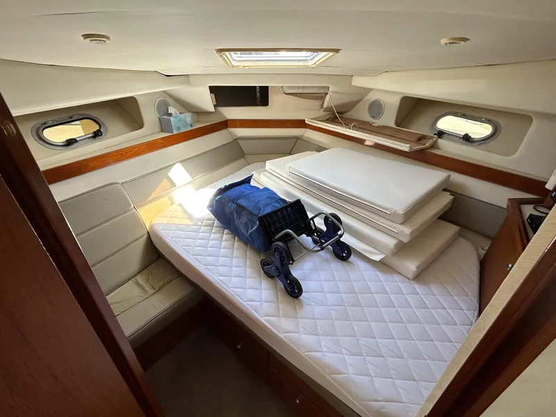 1994 Bayliner 4587 Motoryacht cabin with mattress, cushions, and a folded stroller.
