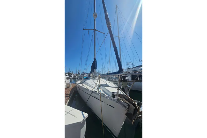 1996 Beneteau Oceanis 440 sailboat docked under clear blue sky.