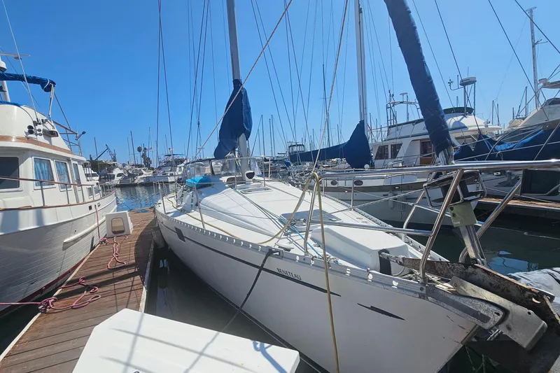 1996 Beneteau Oceanis 440 sailboat docked in a marina, surrounded by other boats.