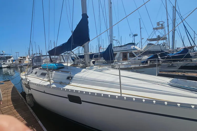1996 Beneteau Oceanis 440 sailboat docked at a marina under clear blue skies.