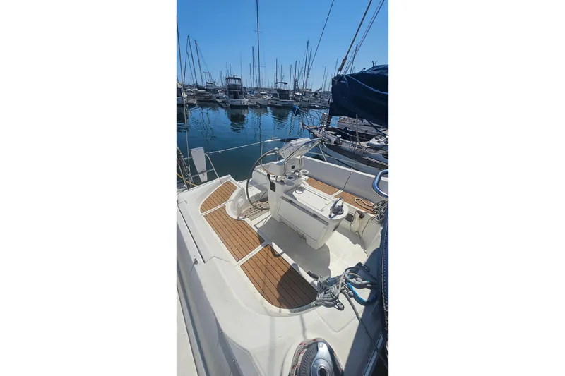 1996 Beneteau Oceanis 440 sailboat cockpit with wooden deck, docked in marina.