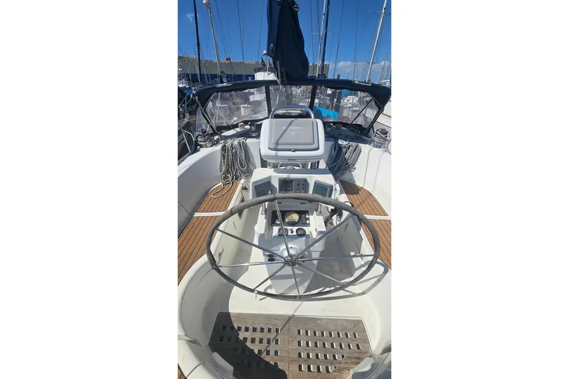 Cockpit view of 1996 Beneteau Oceanis 440 sailboat with steering wheel and navigation instruments.