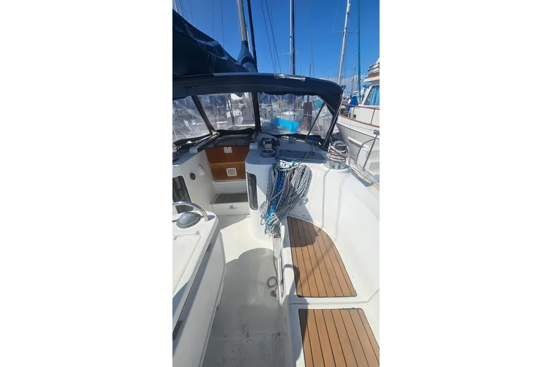 Cockpit of 1996 Beneteau Oceanis 440 sailboat with wooden seating and nautical equipment.