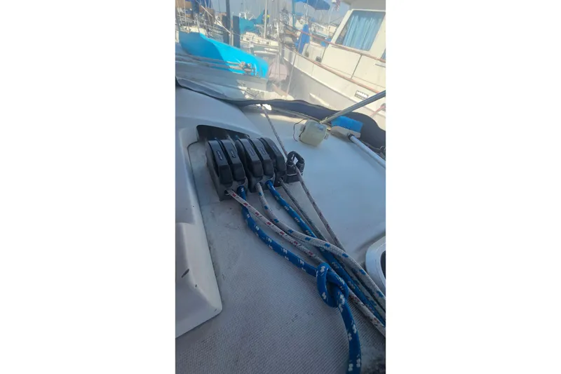 Deck of 1996 Beneteau Oceanis 440 sailboat with rope clutches and lines.
