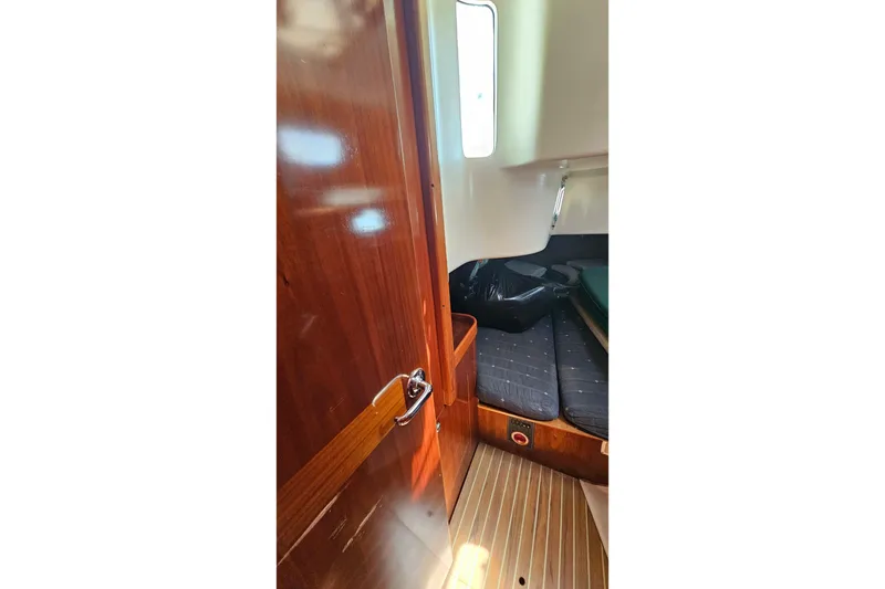 Interior cabin of 1996 Beneteau Oceanis 440 sailboat with wooden finish and cozy seating.
