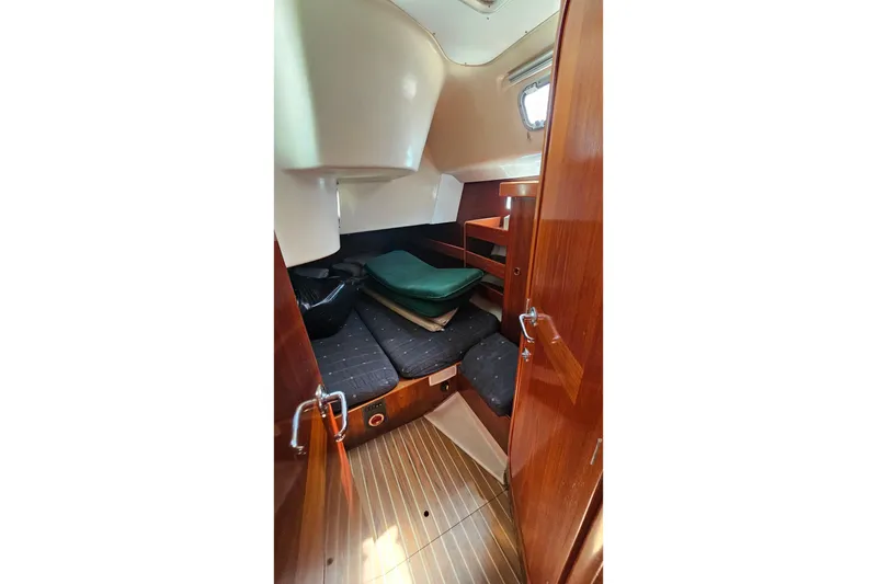 Interior cabin of 1996 Beneteau Oceanis 440 sailboat with wooden finish and cozy seating.