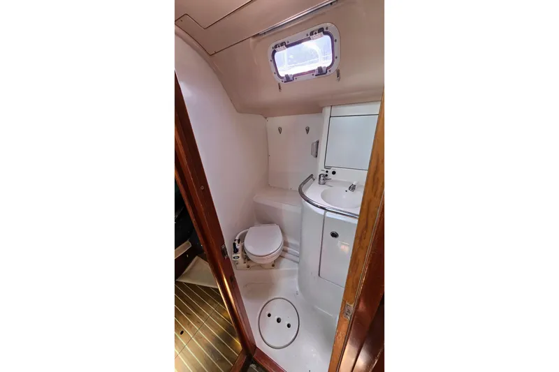 Bathroom interior of 1996 Beneteau Oceanis 440 yacht, featuring toilet and sink.