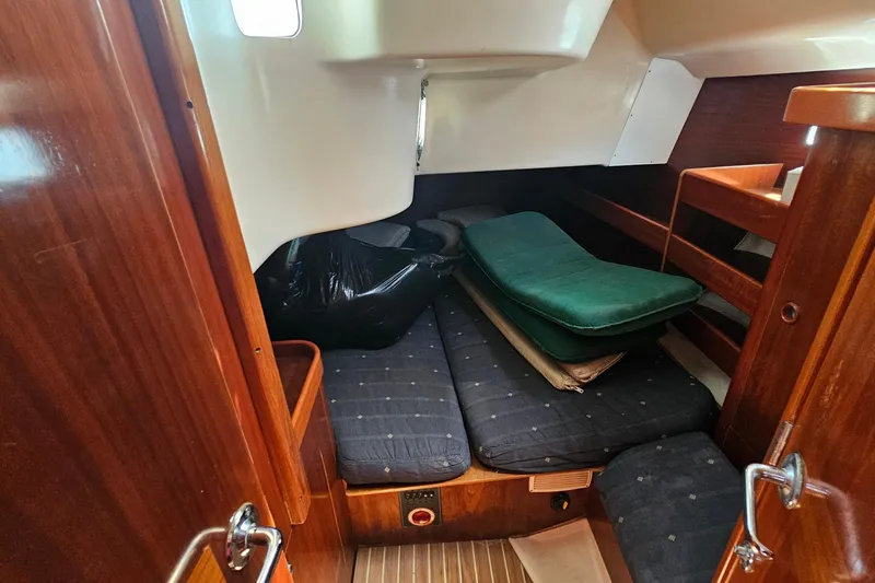 Interior cabin of 1996 Beneteau Oceanis 440 sailboat with wooden finish and cushions.
