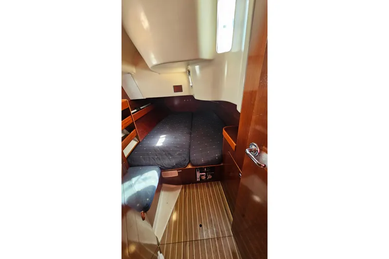 1996 Beneteau Oceanis 440 cabin interior with wooden finish and cozy sleeping area.