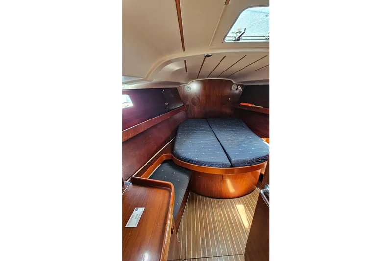 1996 Beneteau Oceanis 440 cabin interior with wooden finish and cozy bed.