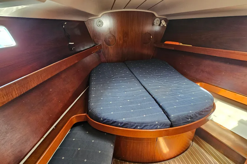 1996 Beneteau Oceanis 440 cabin interior with wooden finish and blue mattress.