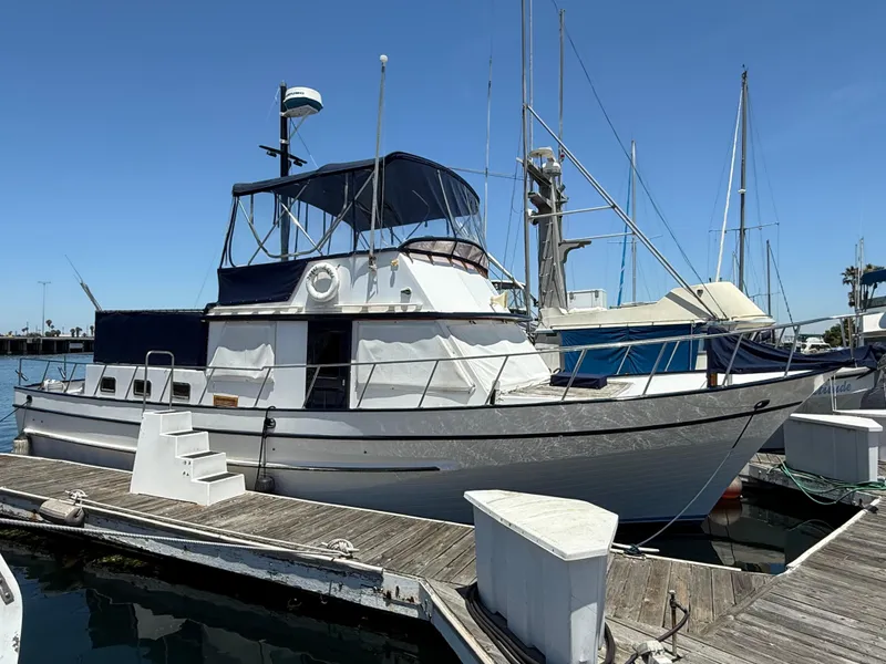 1981 DeFever Passagemaker yacht docked at marina under clear blue sky.