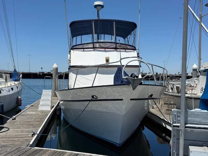 1981 DeFever Passagemaker yacht docked at marina under clear blue sky.