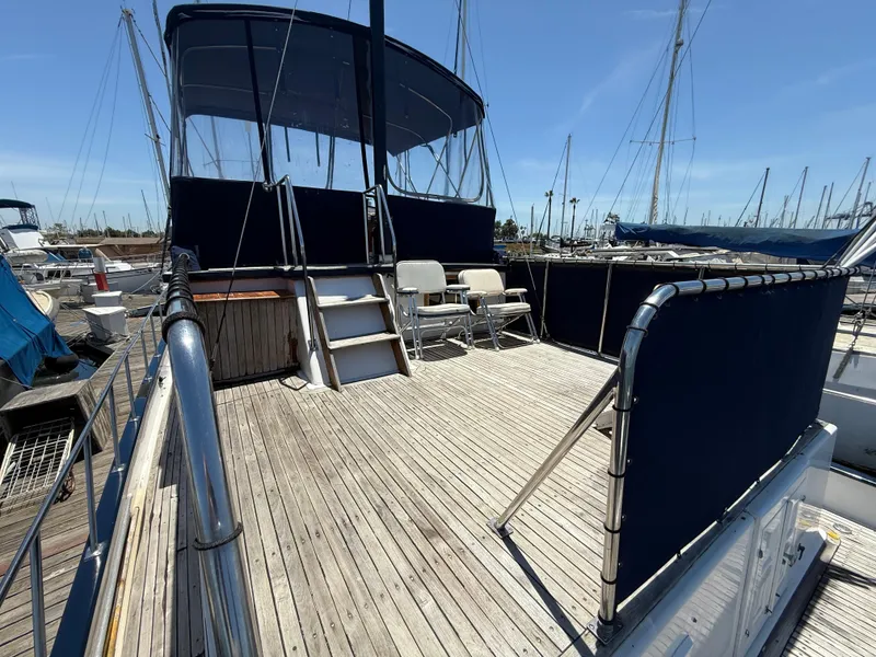 1981 DeFever Passagemaker yacht deck with seating and canopy in marina.
