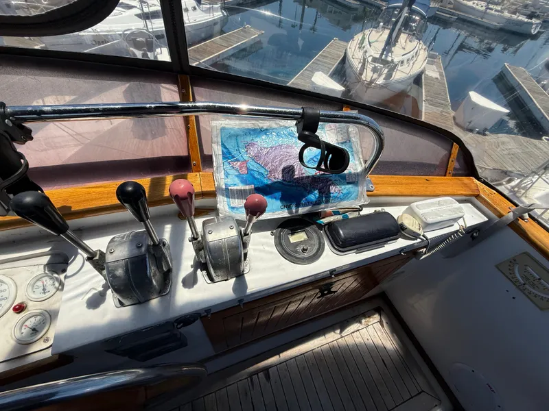 1981 DeFever Passagemaker helm with controls, map, and marina view.