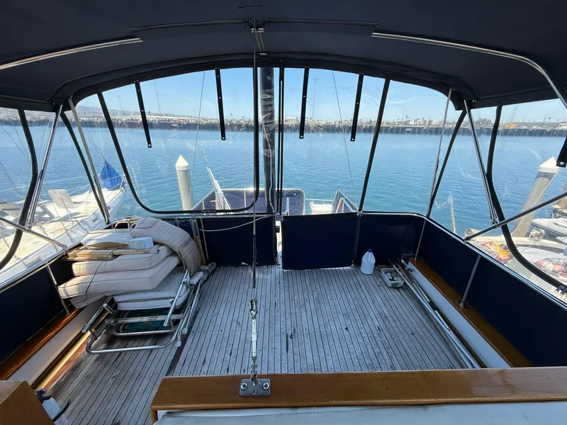 1981 DeFever Passagemaker yacht deck with seating, overlooking marina and calm waters.