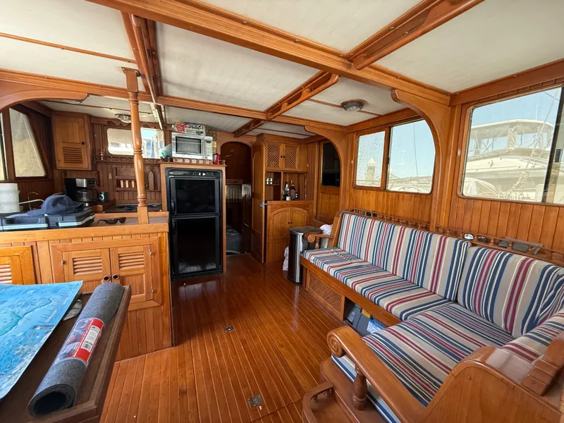 1981 DeFever Passagemaker interior with wood paneling and striped seating.
