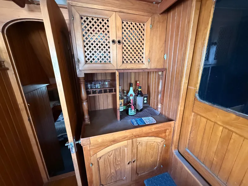 1981 DeFever Passagemaker interior with wooden cabinetry and liquor storage.