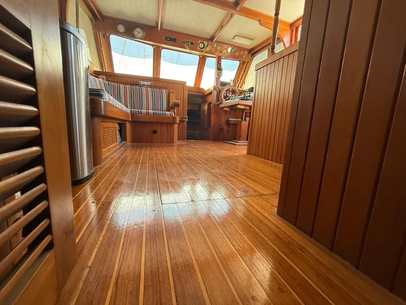 Interior of 1981 DeFever Passagemaker with polished wood flooring and nautical decor.