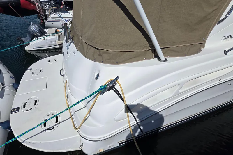 2002 Sea Ray 340 Sundancer docked, featuring swim platform and mooring lines.