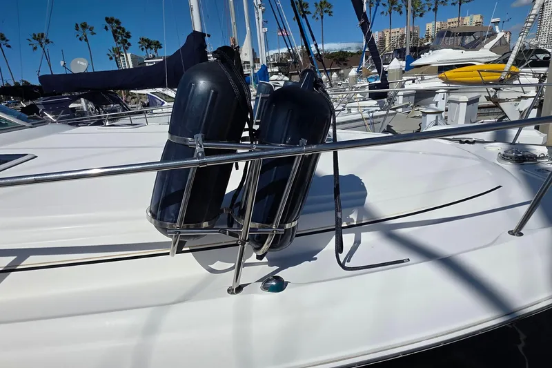 2002 Sea Ray 340 Sundancer with fenders docked at marina, palm trees in background.