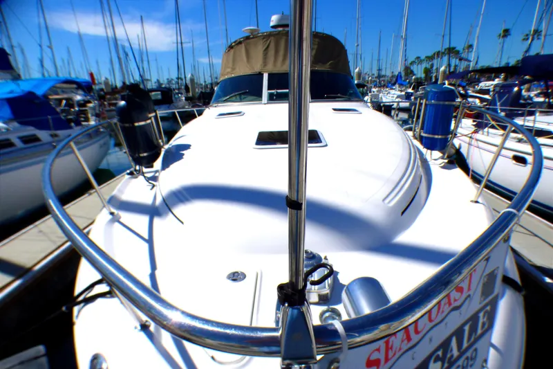 2002 Sea Ray 340 Sundancer yacht docked at marina, surrounded by sailboats.