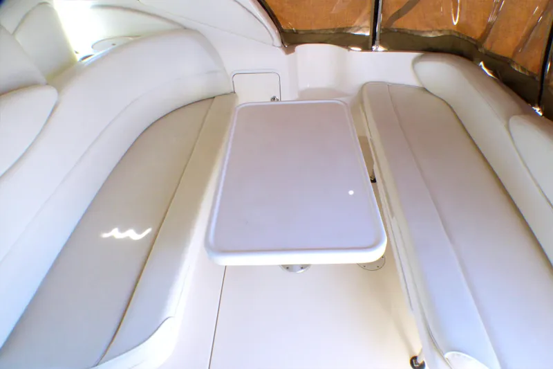 2002 Sea Ray 340 Sundancer interior with white seating and table.